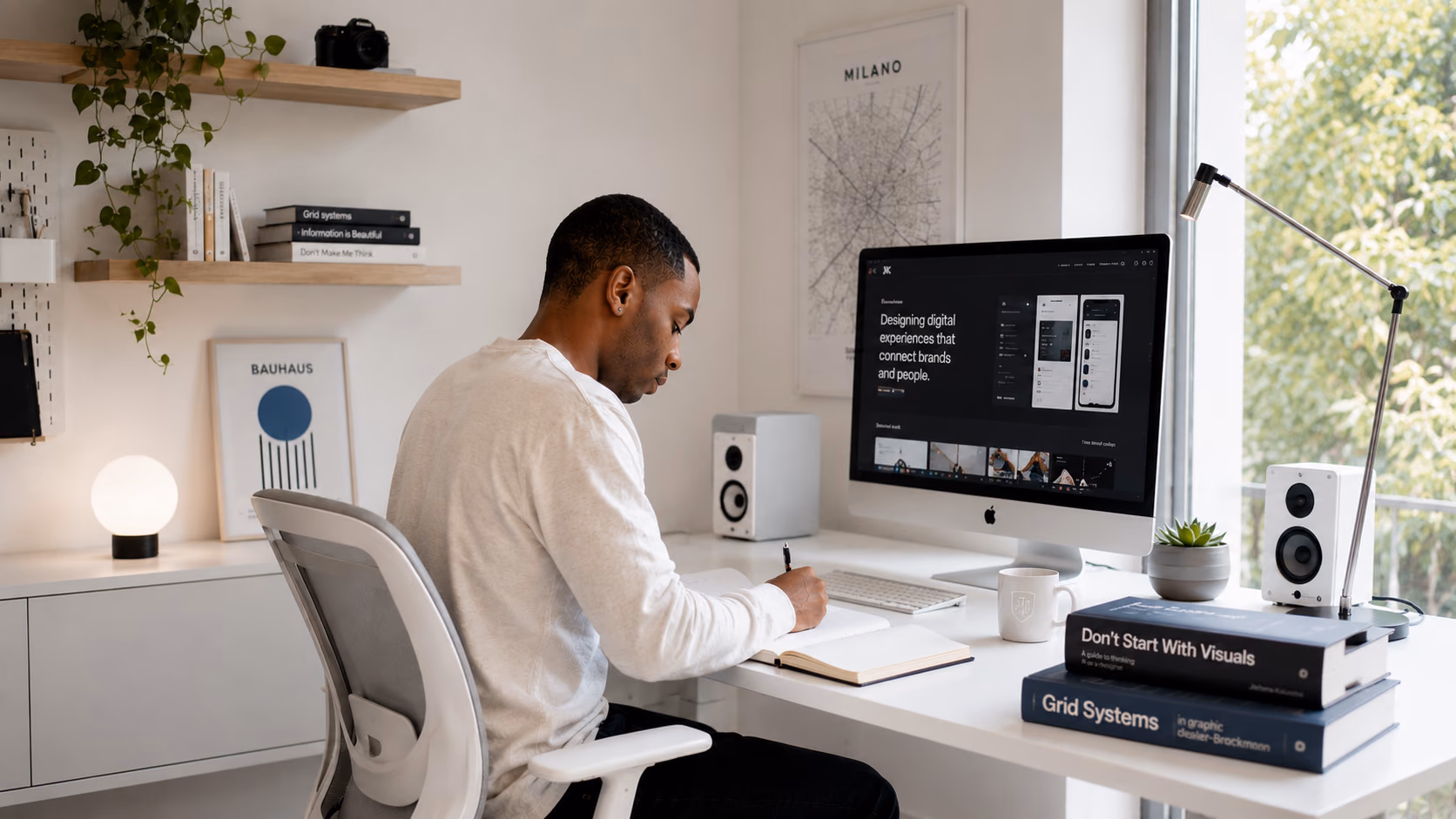 Jerome Kalumbu working at his home-office desk in Milan